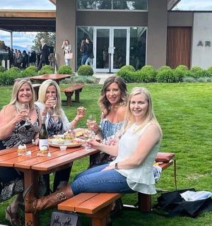 一群妇女坐在野餐桌旁