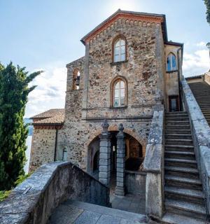 a stone building with stairs next to the water