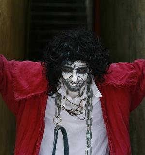 ein als Joker verkleideter Mann mit erhobenen Händen