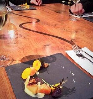 stůl s talířem jídla a sklenkou vína