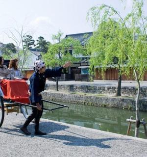 一名男子拉着一辆载有两人的马车
