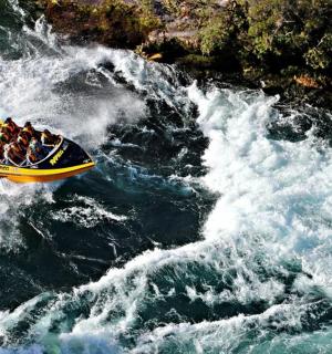 a group of people riding in a raft on a river