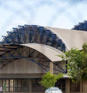 一栋屋顶呈弧形的建筑,前面有一辆汽车