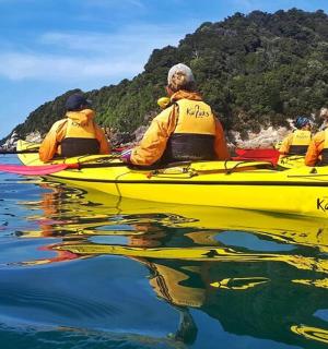 Skupina lidí ve žlutém kajaku na vodě