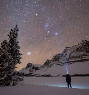 一个人站在星空下的雪地里