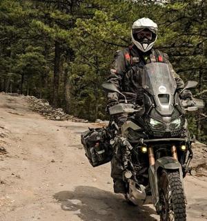 一名男子在土路上骑摩托车