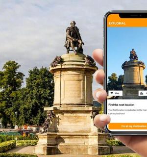 一个人在雕像前举着手机