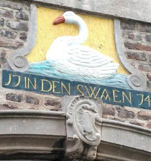 ein Schild mit einem Schwan an der Seite eines Gebäudes