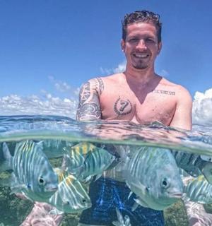 a man is standing in the water with fish