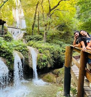 三个人坐在瀑布附近的桥上