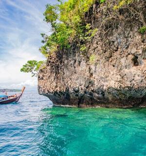en båd i vandet ved siden af en klippe