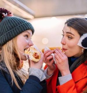 Dvě ženy jedí párky v rohlíku