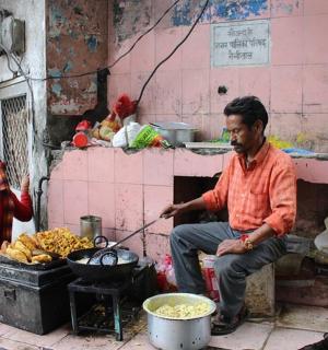 a man sitting in front of a stove with food