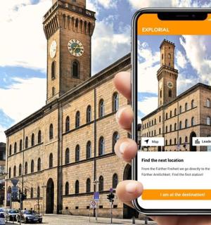 a person holding up a cell phone in front of a building