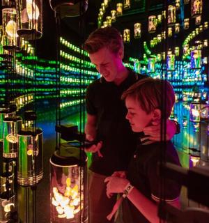 a man and a woman looking at a machine with lights