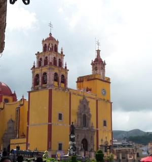 一座黄色的建筑,有两座塔楼,塔楼上有一座钟