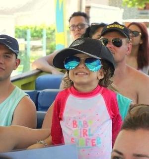 一个戴着墨镜和帽子的小女孩和一群人