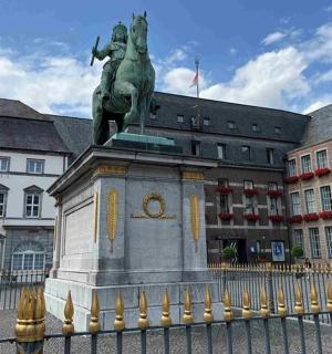 a statue in front of a building with a fence