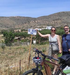a man and woman standing next to a sign with a bike