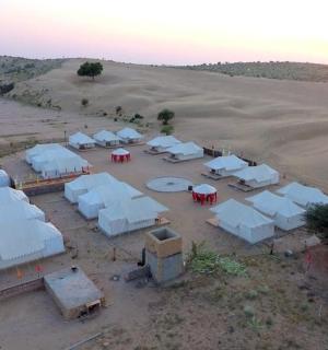 skupina bílých stanů uprostřed pouště