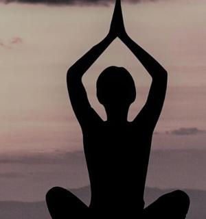 žena cvičící jógu před západem slunce