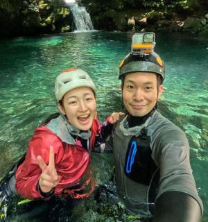 一名男子和一名女子在瀑布河中