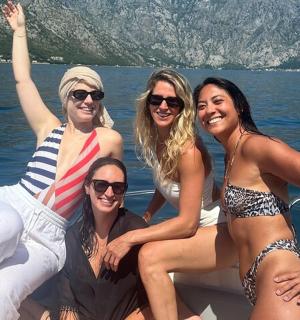 a group of women sitting on a boat in the water