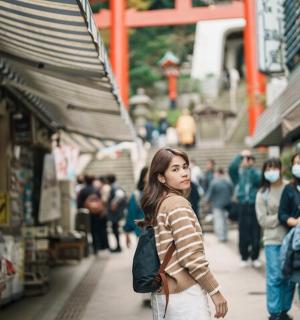 a woman walking down a street in a market