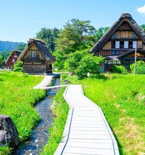 a walkway in front of a house and a river