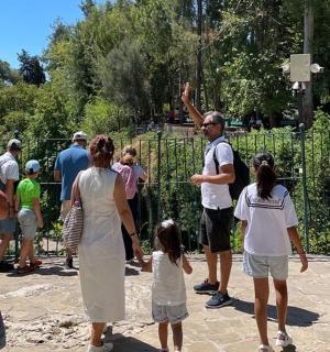 a group of people standing around a fence at a zoo