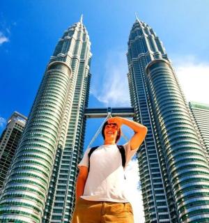 a man standing in front of two tall buildings