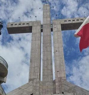 před křížem vlaje vlajka