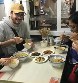 a group of people sitting around a table eating food