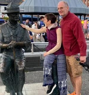 a man and a woman standing next to a statue