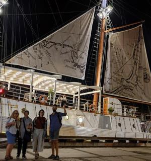 a group of people standing in front of a boat
