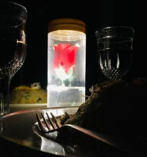 a table with a plate of food and two wine glasses