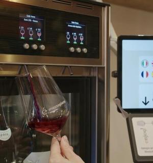 a person holding a glass of wine in front of an oven
