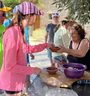 a group of people standing around a table preparing food