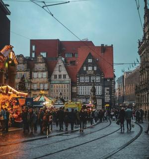 a crowd of people walking down a street in a city