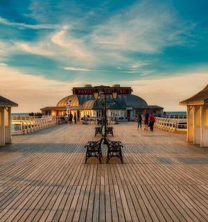 a boardwalk with a pier with people walking on it