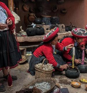 skupina žen v tradičním oděvu připravujících jídlo