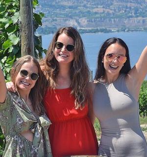 三位女士举着她们的酒瓶