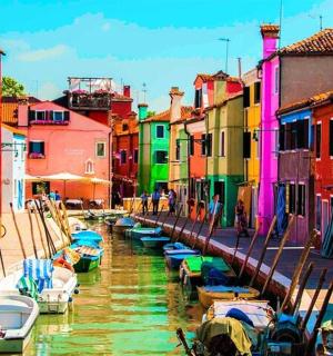 Skupina lodí v kanálu s barevnými budovami