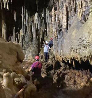 skupina lidí procházejících se jeskyní