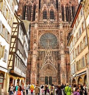 a crowd of people walking in front of a cathedral