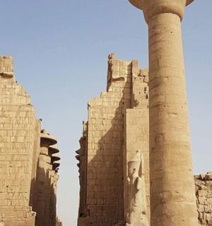 a group of ancient columns and a obelisk