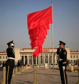 two men in uniform standing in front of a building with a red flag