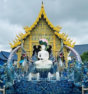 a blue and yellow structure with a statue in front