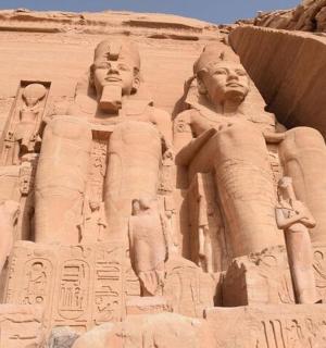 a large statue of two people in the desert