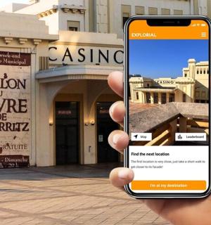 一只手拿着手机站在建筑物前